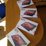 cztery tablety w pudełkach na stoliku